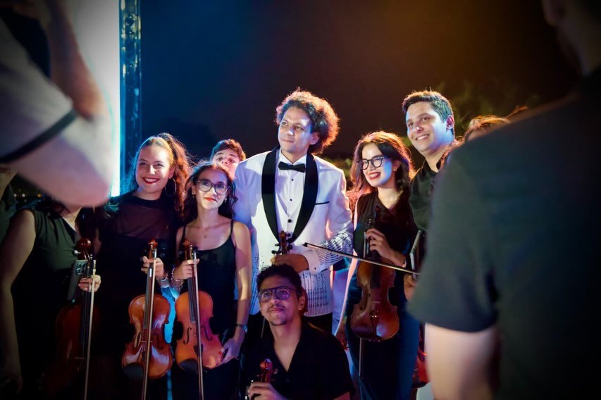 The violinists on stage inside the ring of LED pillars